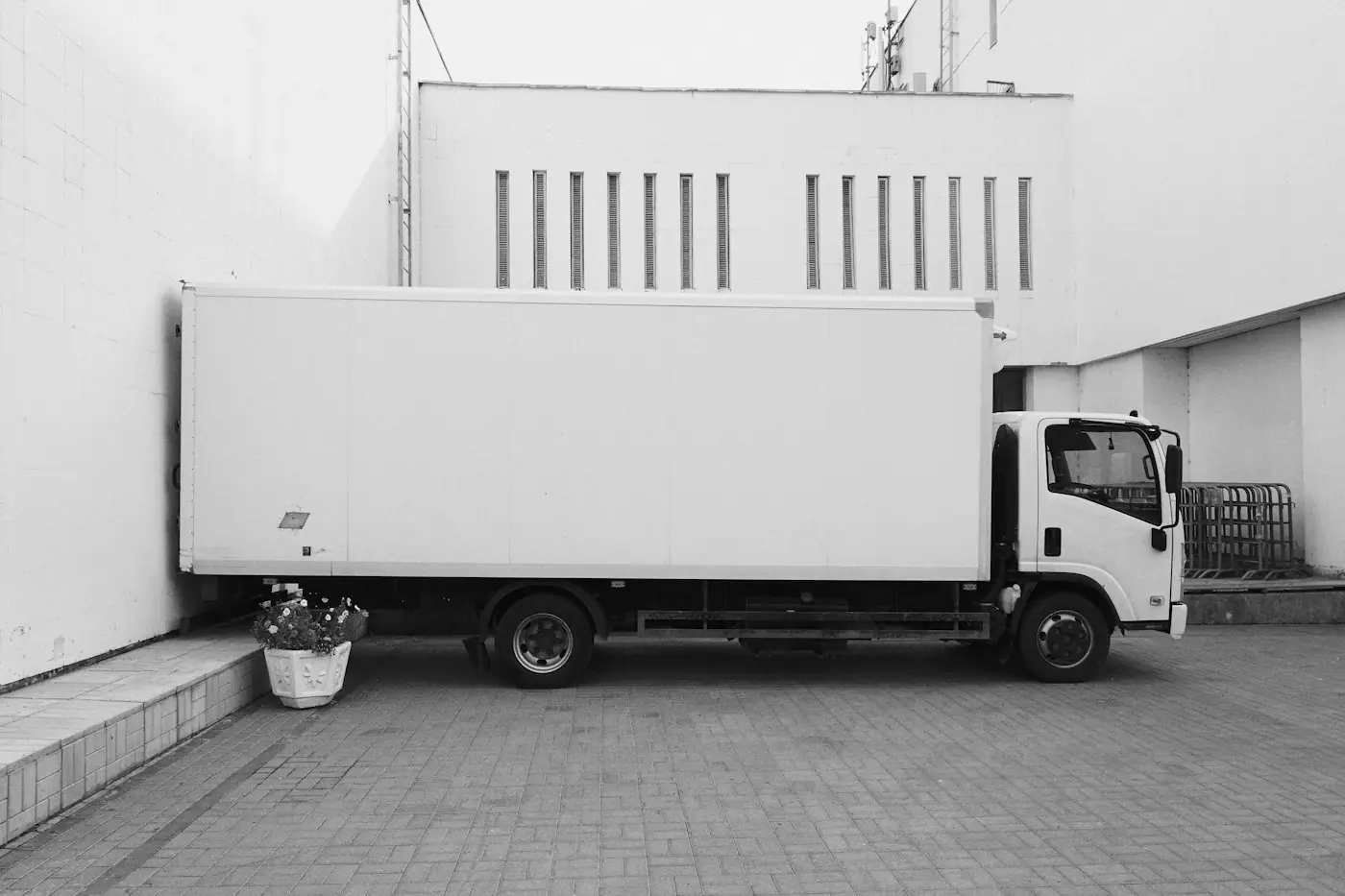 A white box truck parked outside a building