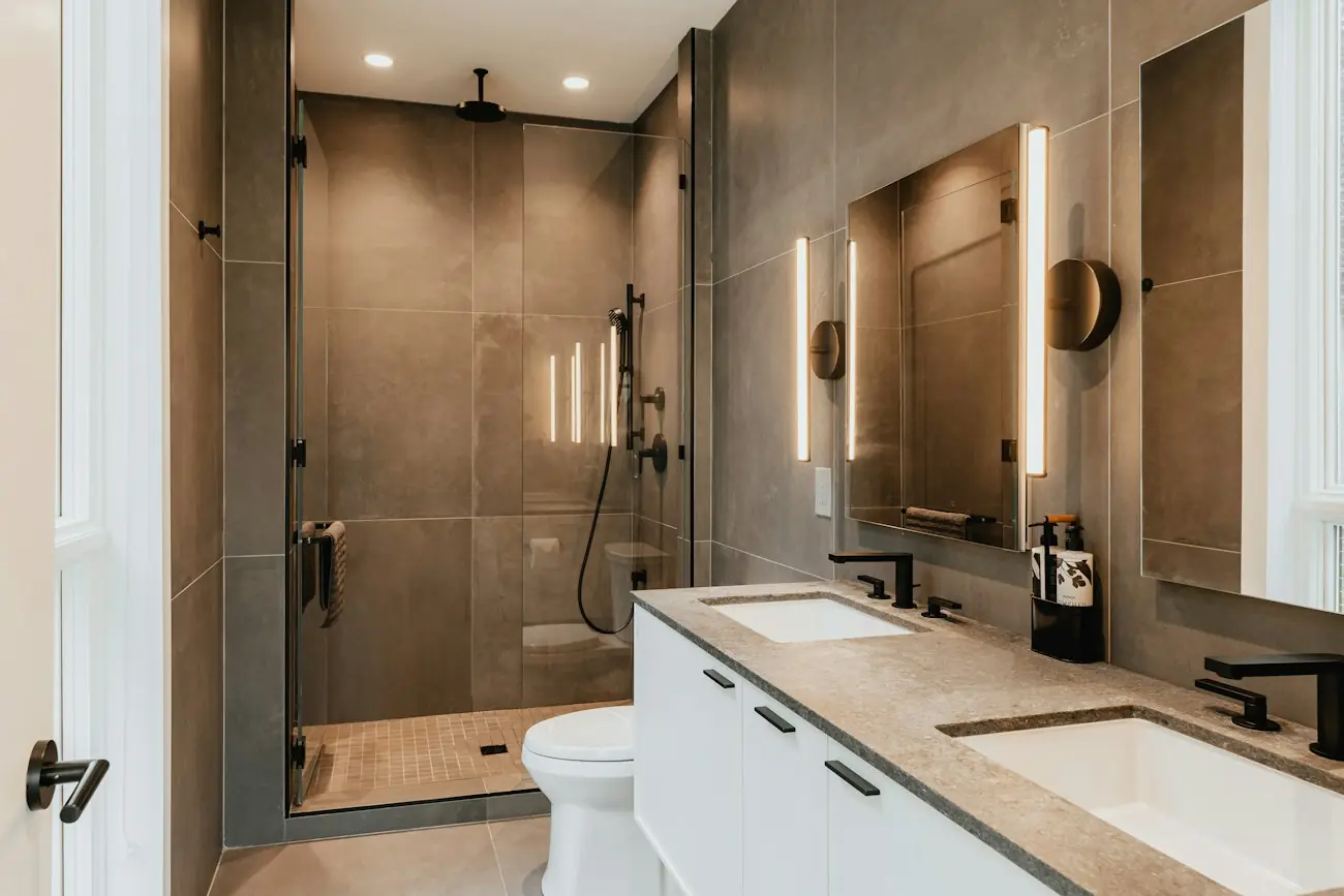 A primary bathroom with large-format tile, a walk-in shower and a floating double vanity
