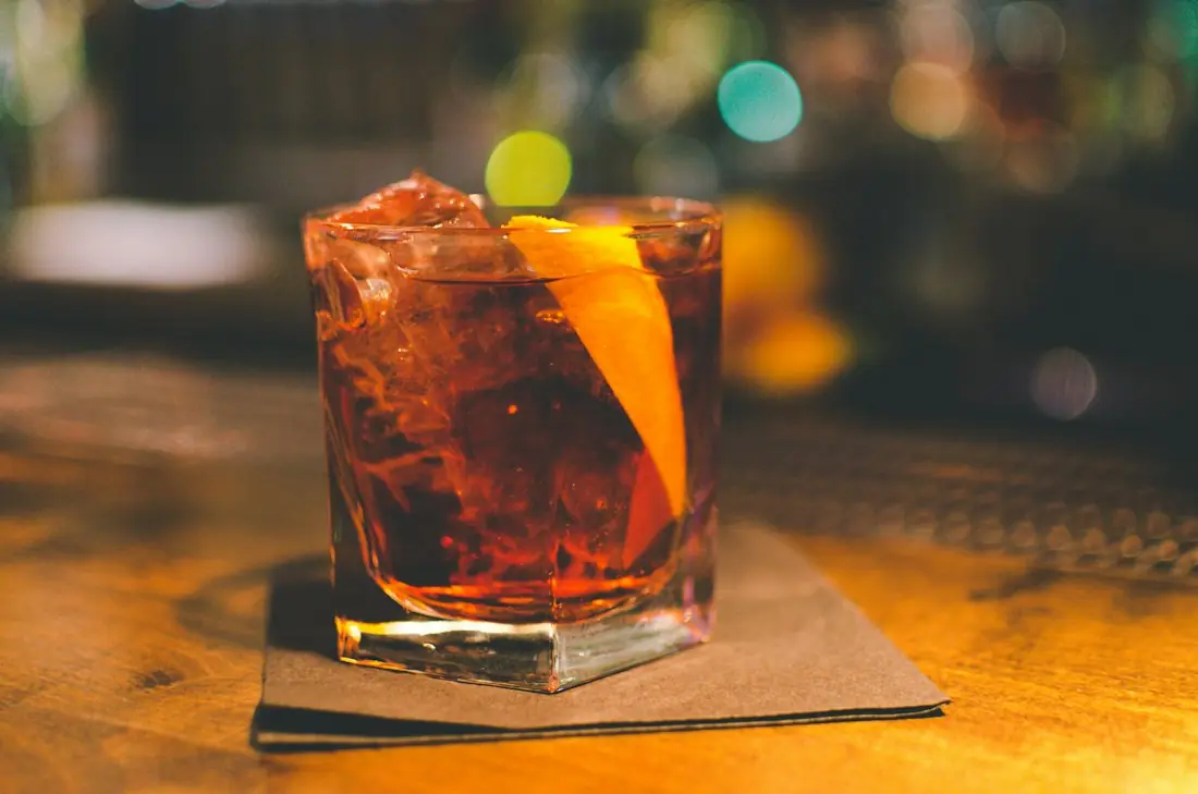 A negroni with an orange twist on the bar