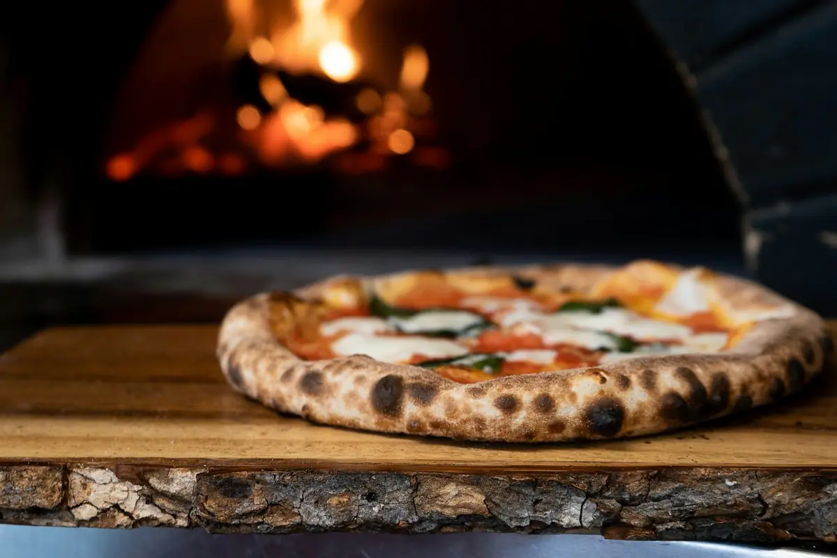 A wood-fired pizza with a leopard-spotted crust